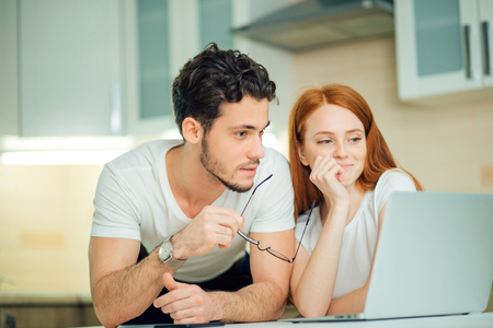 couple with laptop spending time together at homeの写真素材