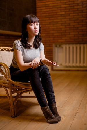 Asian woman smiling to camera on brick wallの写真素材
