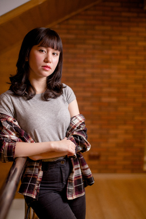 Asian woman smiling to camera on brick wallの写真素材