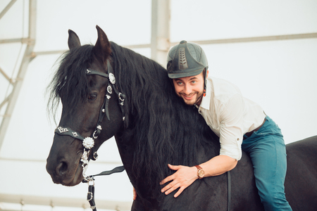 man in a shirt riding on a brown horseの写真素材