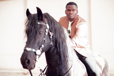 man riding brown horse on countrysideの写真素材