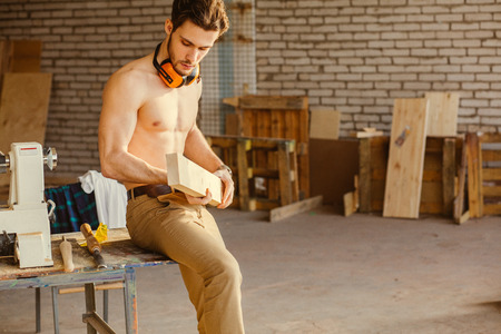 carpenter testing wood plank evenness at workshopの写真素材