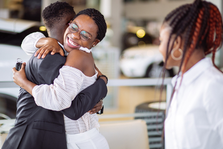 Couple collecting new car from salesman on lotの写真素材