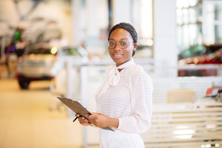 Professional female salesperson working in car dealershipの写真素材