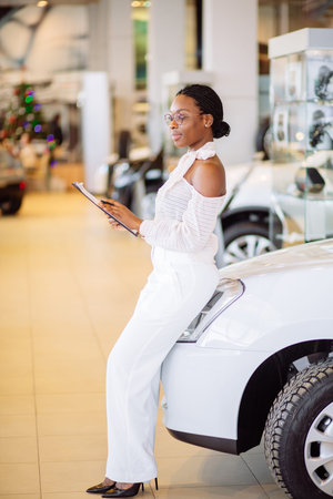 Professional female salesperson working in car dealershipの写真素材