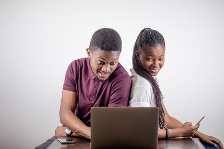 black girl sitting in front of laptop s looking on screenの写真素材