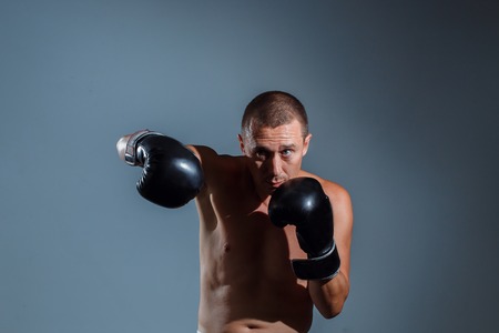 Boxing fighter trainning indoor on grey backgroundの写真素材