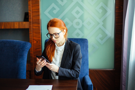 Businesswoman wearing glasses using digital tablet in officeの写真素材
