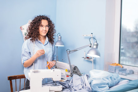 pretty tailor is going to cut fabric with yellow scissors
