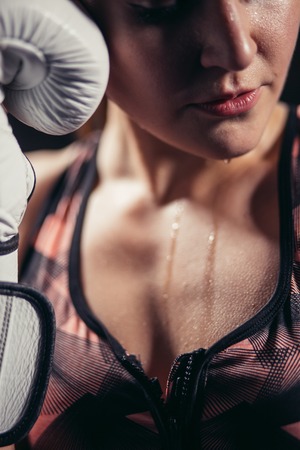 Female Boxer wearing gloves posing in boxing studioの写真素材