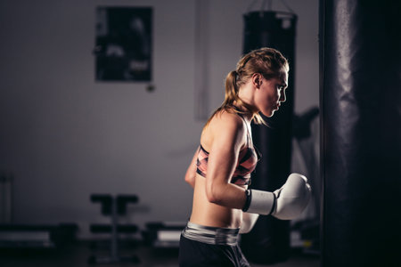 fighter girl wearing sportswear punching bag