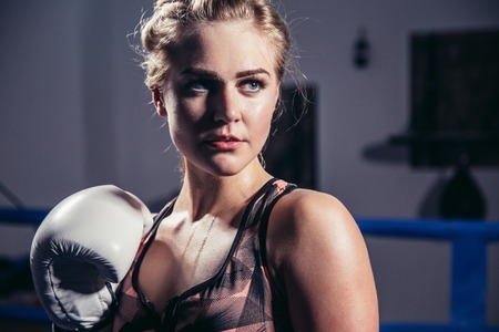 Female Boxer wearing gloves posing in boxing studioの写真素材