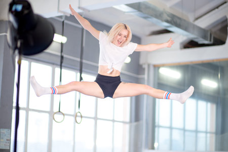 Twine jumping young woman on the trampoline