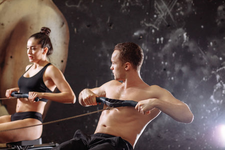 couple doing exercises with rowing machine