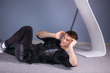 athlete wearing ems suit doing abs exercise or sit upsの写真素材