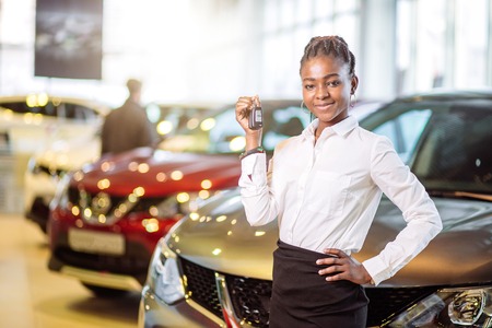 african woman with her new car showing keyの写真素材