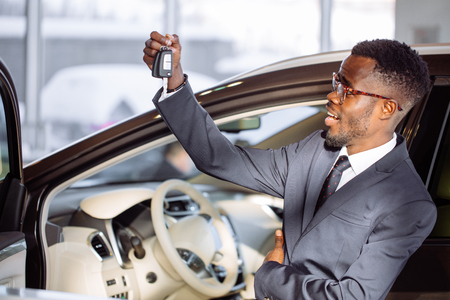 Young African Businessman Sitting In A Car Showing Car Keyの写真素材
