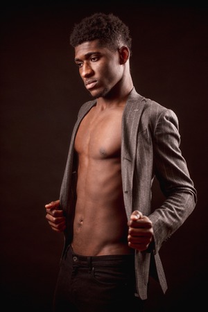 side view shot of black man taking off his new suit jacketの写真素材