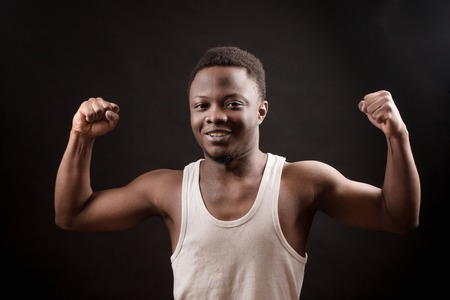 young African amateur bodybuilder bending elbow the bicepsの写真素材