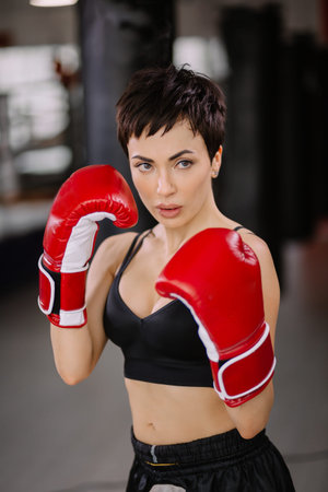 portrait of fealess woman doing shadow boxing at sport centre