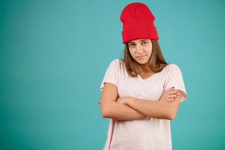 close up shot of model in red cap standing with crossed arms.の写真素材