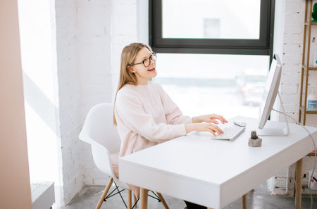 businesswoman typing on keyboard in bright office