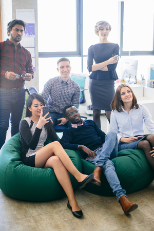 young ambitious multiethnic group of business people standing restingの写真素材