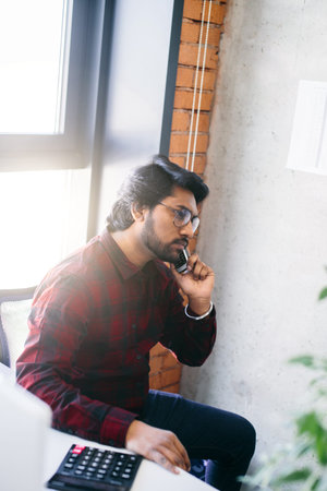 closeup side view shot of brutal Hindoo accountant inspector with smartphone