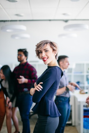 close up portrait of joyful businesswoman with crossed arms showing tongueの写真素材