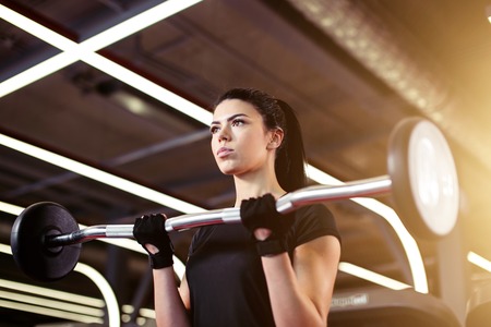 fitness, close up of young woman pick up for biceps in gymの写真素材