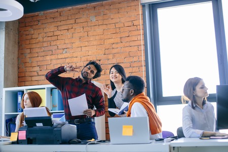 hindoo man and Chinese woman are posing to the camera at workplaceの写真素材
