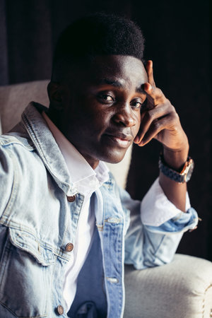 african young man sitting in cafe and waiting for coffee