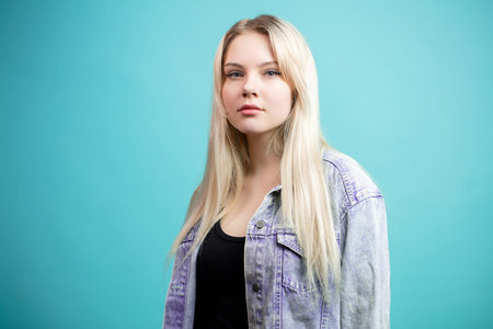 Blonde young woman isolated over blue background.