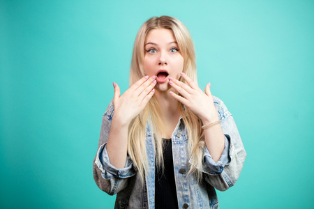 Portrait of surprised blonde woman in denim jacketの写真素材