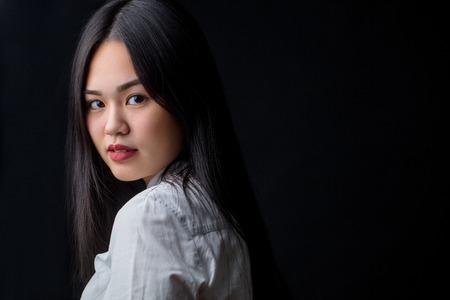 Asian young woman in white over black background. Black and White Contrast, Beauty, People conceptの写真素材