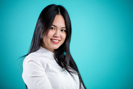 Beautiful young Asian woman isolated on blue backgroundの写真素材