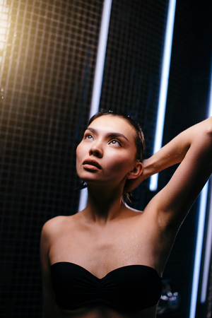 close up portrait Asian female wearing black swimsuit standing in bathの写真素材