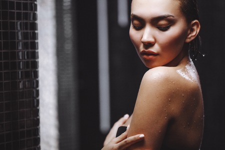 close up portrait of Asian girl having a contrast shower and enjの写真素材