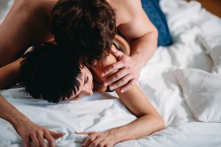 Close up hands of a couple having hot sex on a bedの写真素材