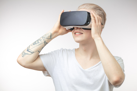 Blonde Man getting experience using VR headset glasses of virtual realityの写真素材