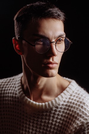 Studio shot of a handsome young male model wearing white T-shirt and sunglassesの写真素材