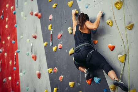 Sporty young woman training in a colorful climbing gym.