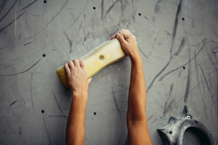 Climber hands holding artificial boulder in climbing gym, closeup shotの写真素材