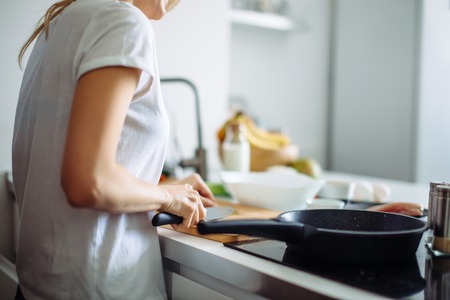 Young female chef cooking in kitchenの写真素材