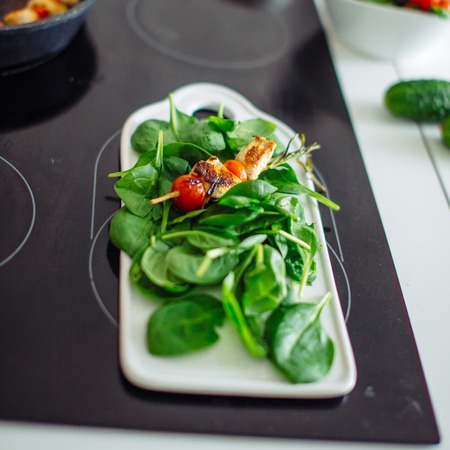 Chicken kebabs served with tomato cherry and greeneryの写真素材