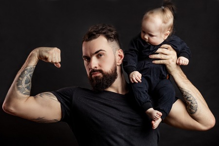 Muscular father holding his little babyの写真素材