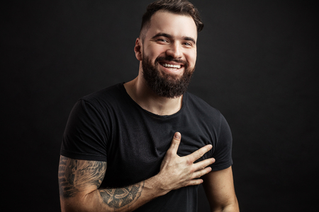 Portrait of handsome young man in casual t-shirt over black background.の写真素材