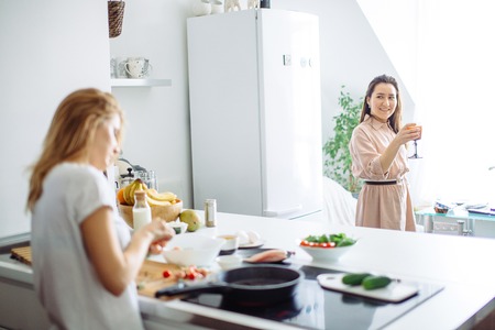 Young housewife making meal for linch in kitchen. rear viewの写真素材