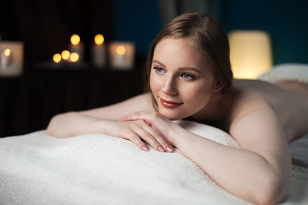 Beautiful woman is waiting anti-aging face massage on spa bed