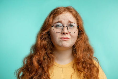 Upset and woman with her damaged dry hair face expression blue background